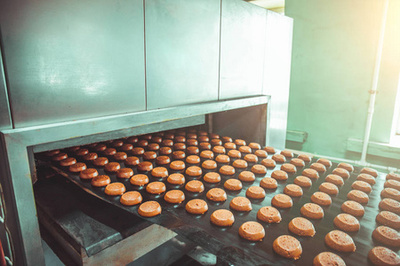 托盘饼干从面团到特殊的立场, 在面包店工厂的炉子做饭。食品工业, 饼干生产